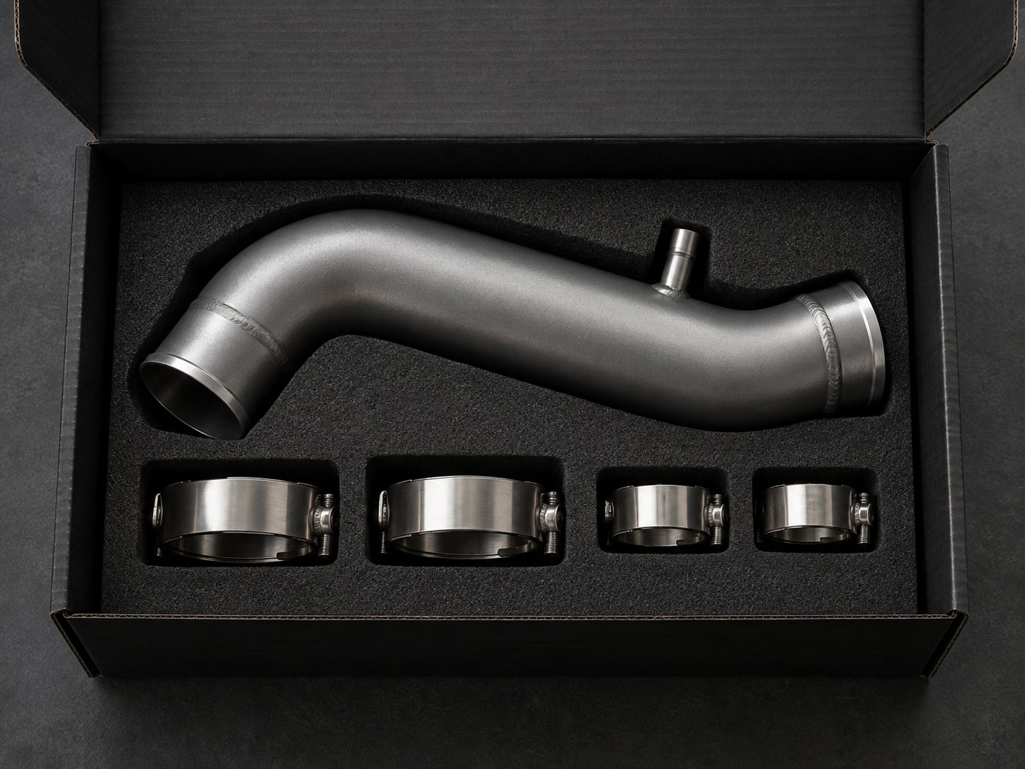 Charge pipe and clamps packed in a foam-lined black shipping box